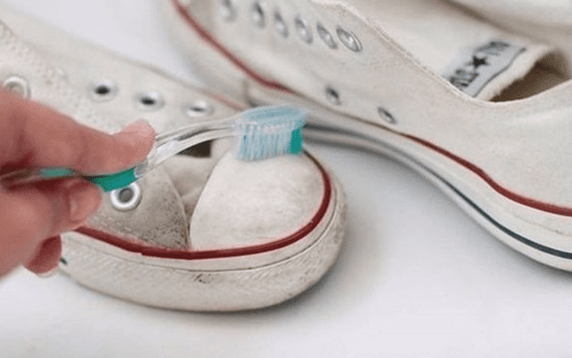 Vệ sinh thân giày bằng bàn chải đánh răng.
